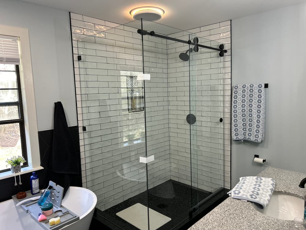 Modern bathroom featuring a glass shower, patterned towels, and sleek fixtures.