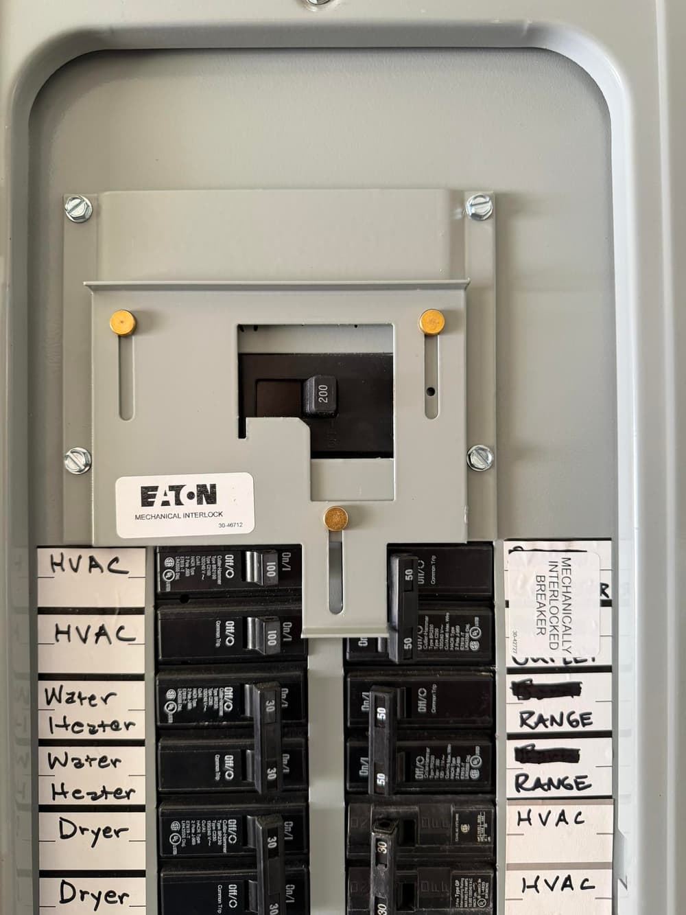 Eaton electrical panel with labeled circuit breakers for HVAC, water heater, dryer, and range.