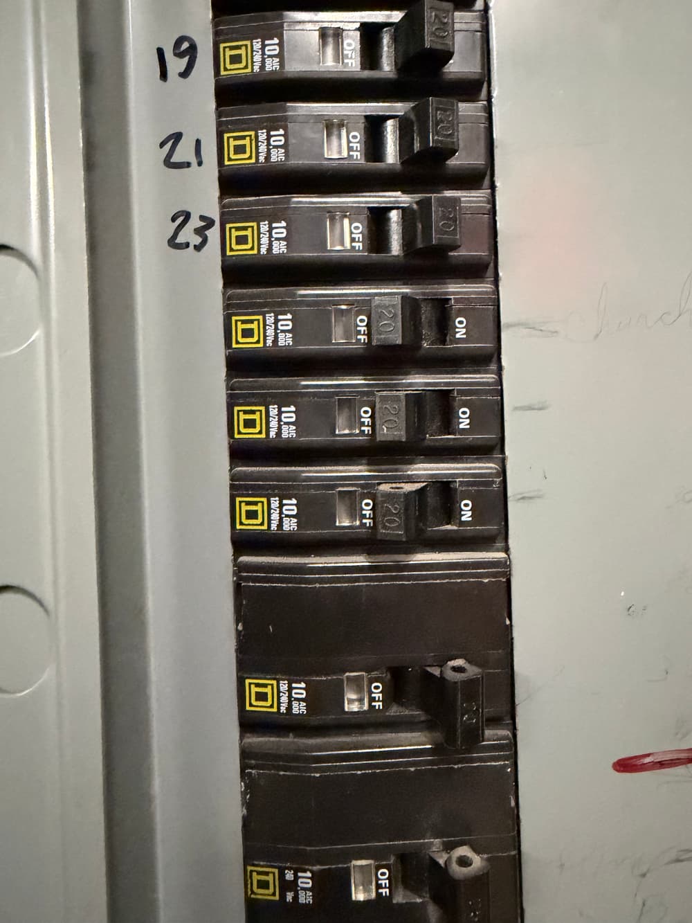 Electrical panel with multiple circuit breakers labeled ON and OFF positions.